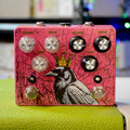 Pink guitar effects pedal with a crowned crow graphic and two sets of volume, drive, and tone knobs with footswitches.