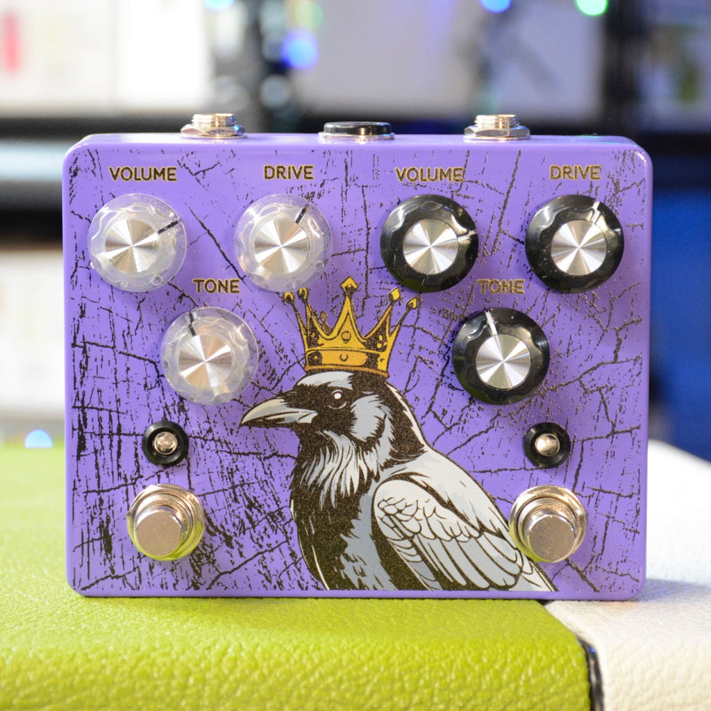 Purple dual overdrive pedal with knobs for volume, drive, and tone, featuring a crowned crow graphic.