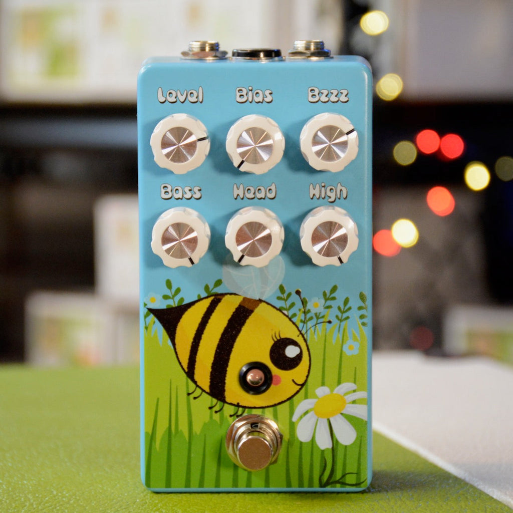 Light blue guitar effects pedal with six white knobs and a bee illustration on the front panel.