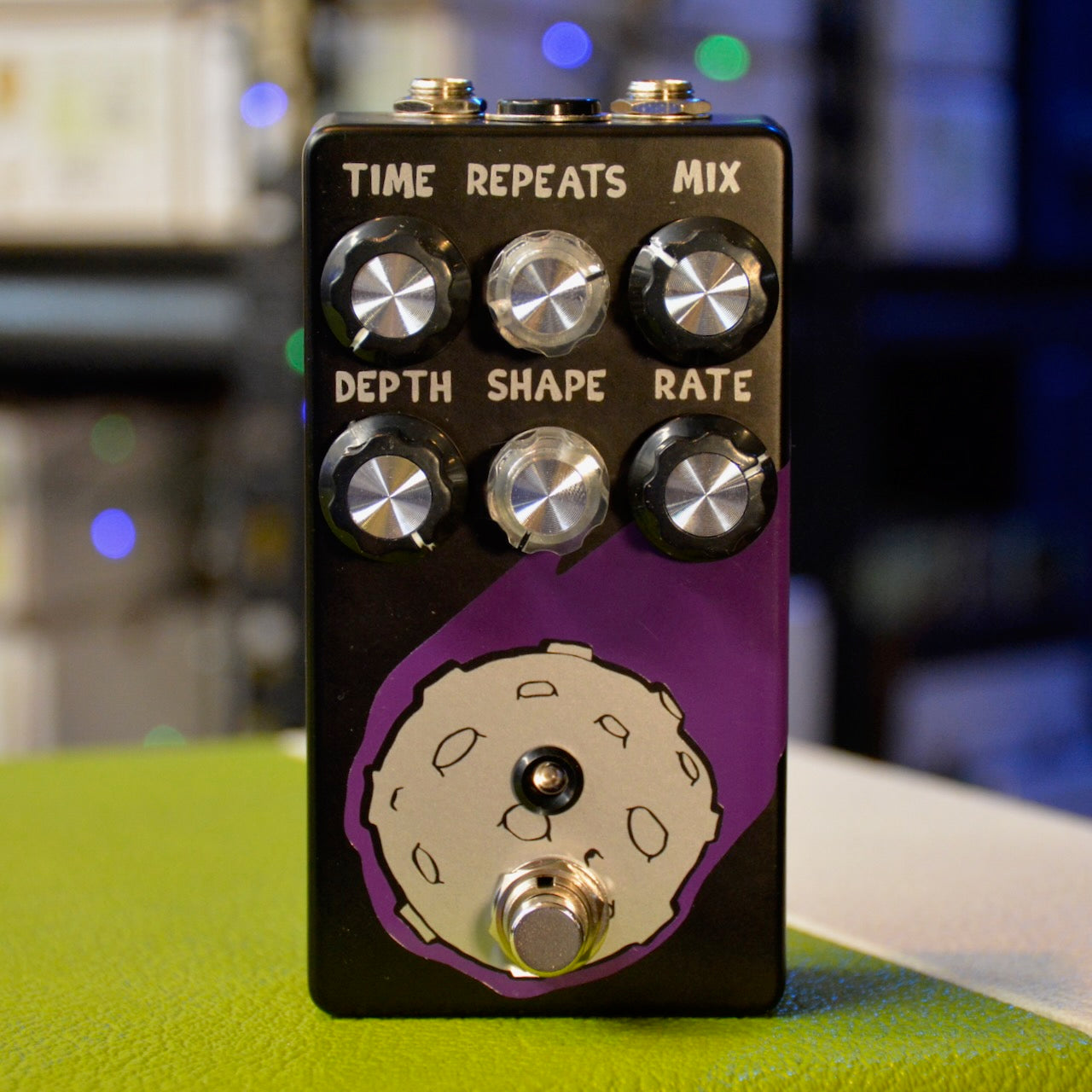 Black and purple guitar effects pedal with six control knobs, a toggle switch, and a footswitch on the front panel