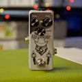 A white guitar effects pedal named The Rewolver with three black knobs and a footswitch.