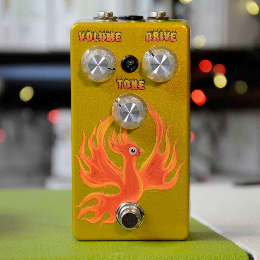 Yellow guitar effects pedal with three control knobs and an orange phoenix graphic on the front.