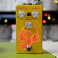 Yellow guitar effects pedal with three control knobs and an orange phoenix graphic on the front.