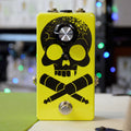 Yellow guitar effects pedal with a black skull and crossed jack plugs design, one rotary knob, and a footswitch button