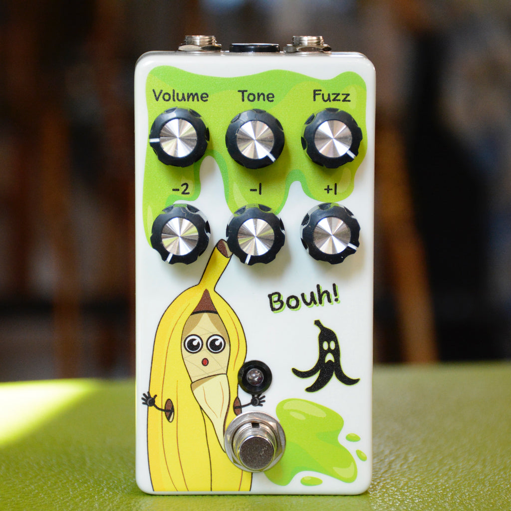 White guitar effects pedal with six control knobs, footswitch, cartoon banana graphic, and 'Bouh!' text.