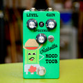 Green guitar effects pedal with three knobs, a toggle switch, and a footswitch, decorated with a cartoon character and text.
