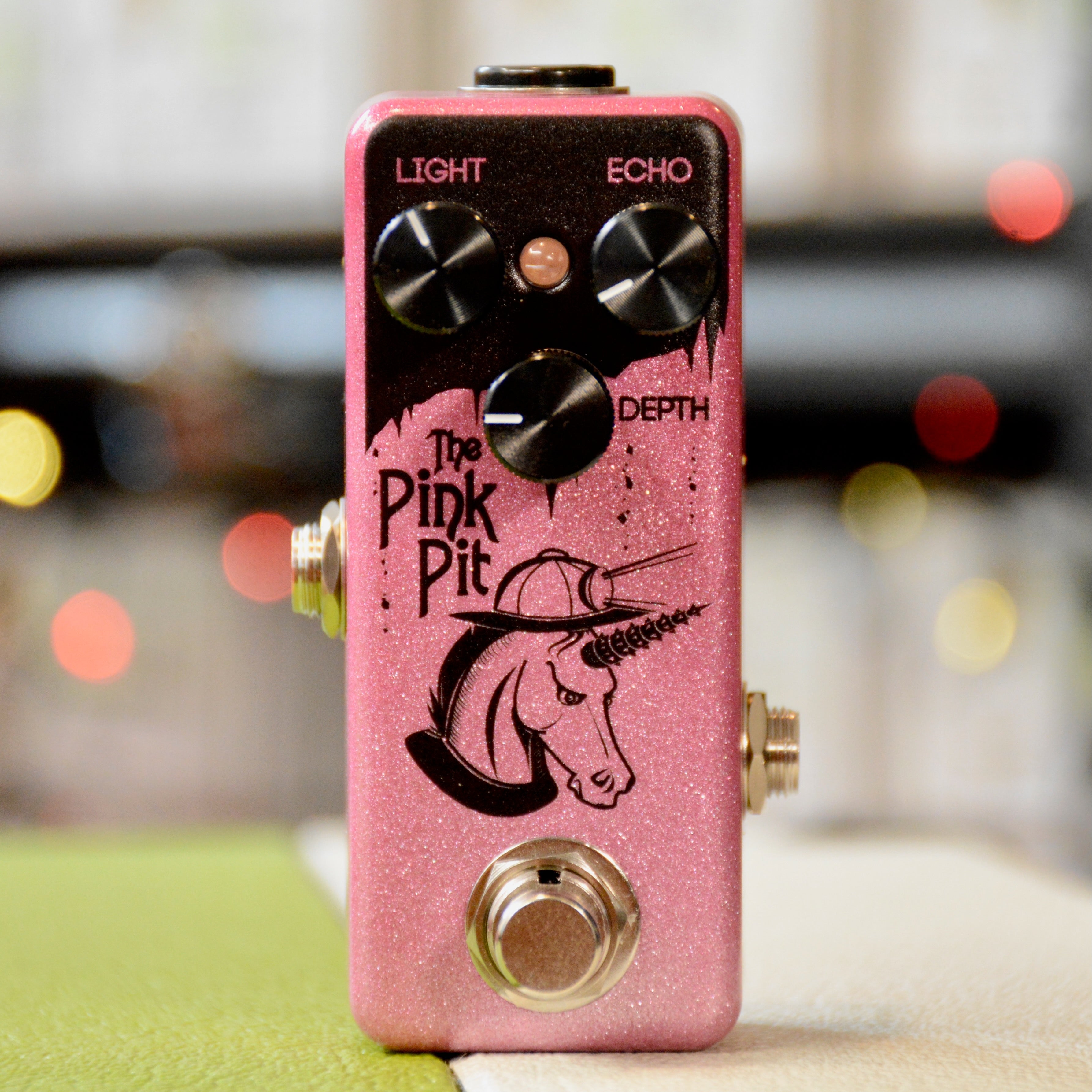 Pink guitar effects pedal with three knobs, one footswitch, and unicorn graphic