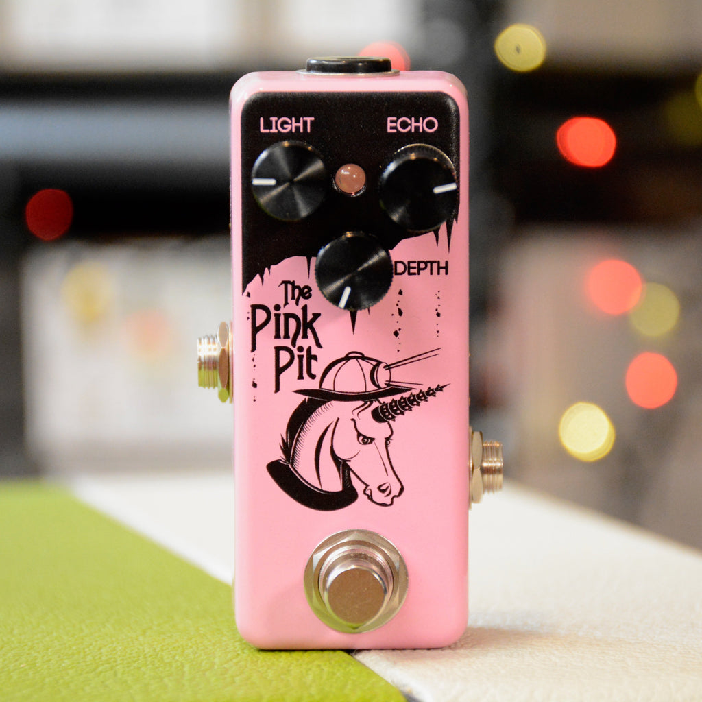 Pink guitar effects pedal with three knobs, a footswitch, and unicorn artwork on the front.