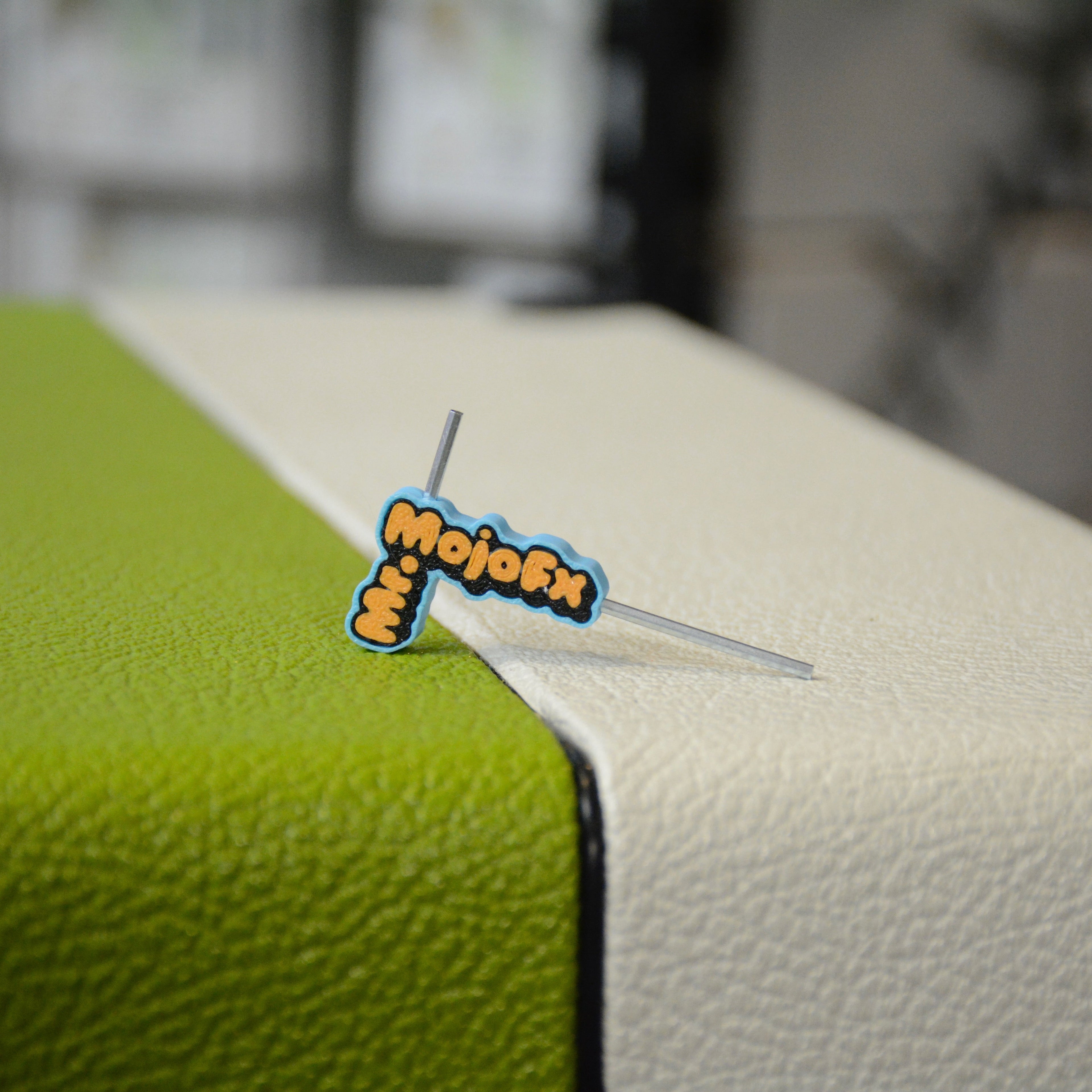L-shaped hex key tool with blue and orange handle labeled Mr MojoFx resting on a green and white surface.