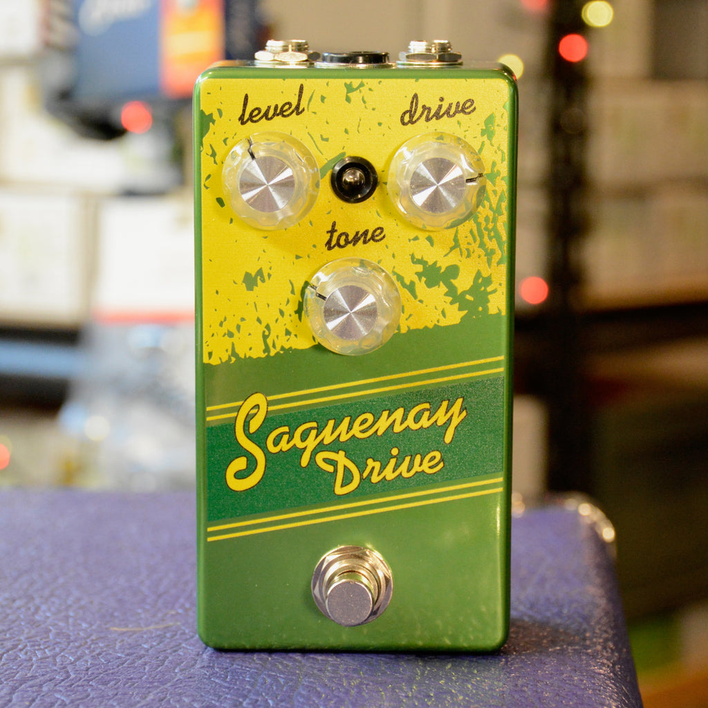 Green and yellow guitar effects pedal with three knobs labeled level, drive, tone, and a footswitch.