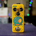 Yellow guitar effects pedal with three control knobs, footswitch, and a graphic of a donut with blue icing and sprinkles.