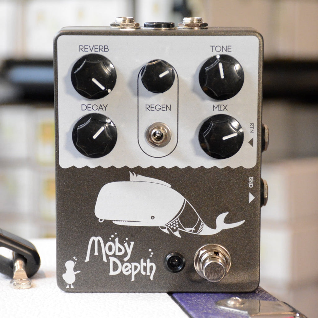 Black guitar effects pedal with five knobs, one toggle switch, one footswitch, and cartoon whale graphic labeled Moby Depth.
