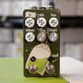 Green guitar effects pedal with six control knobs, two toggle switches, and two footswitches on front panel