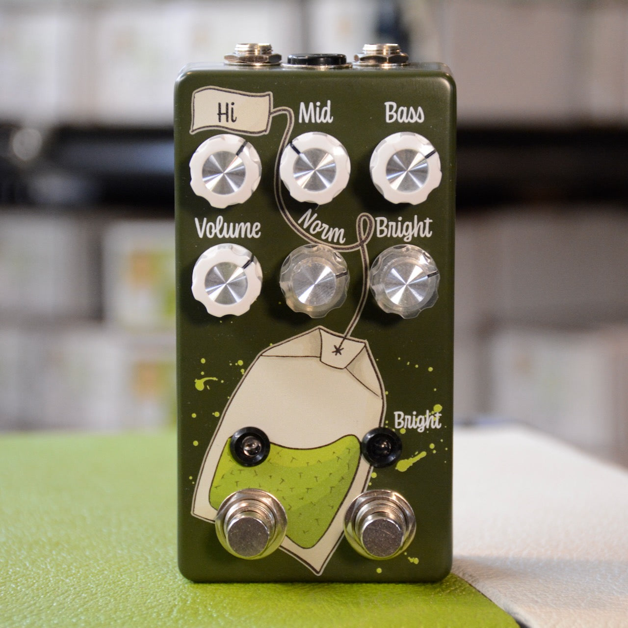 Green guitar effects pedal with six control knobs, two toggle switches, and two footswitches on front panel