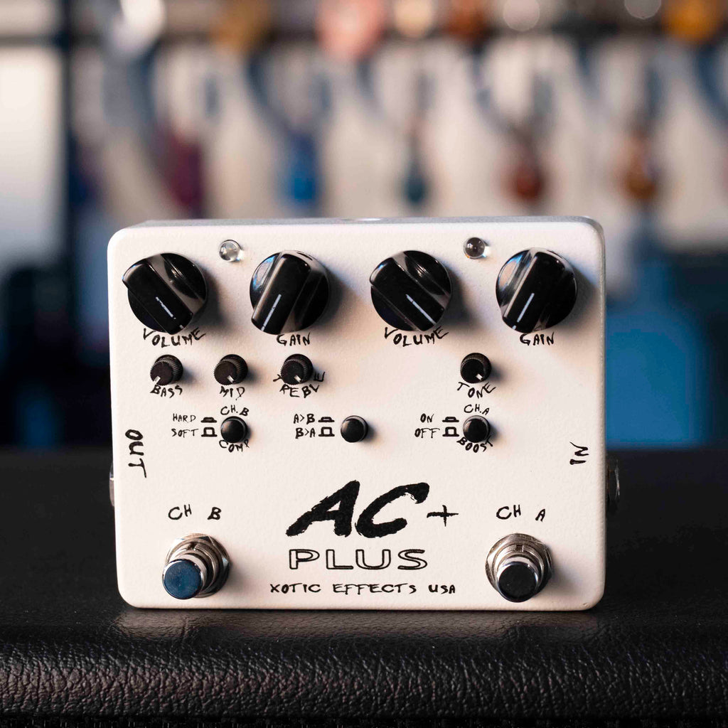 White guitar effects pedal with multiple control knobs, two footswitches, and input/output jacks on sides.