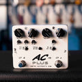 White guitar effects pedal with multiple control knobs, two footswitches, and input/output jacks on sides.