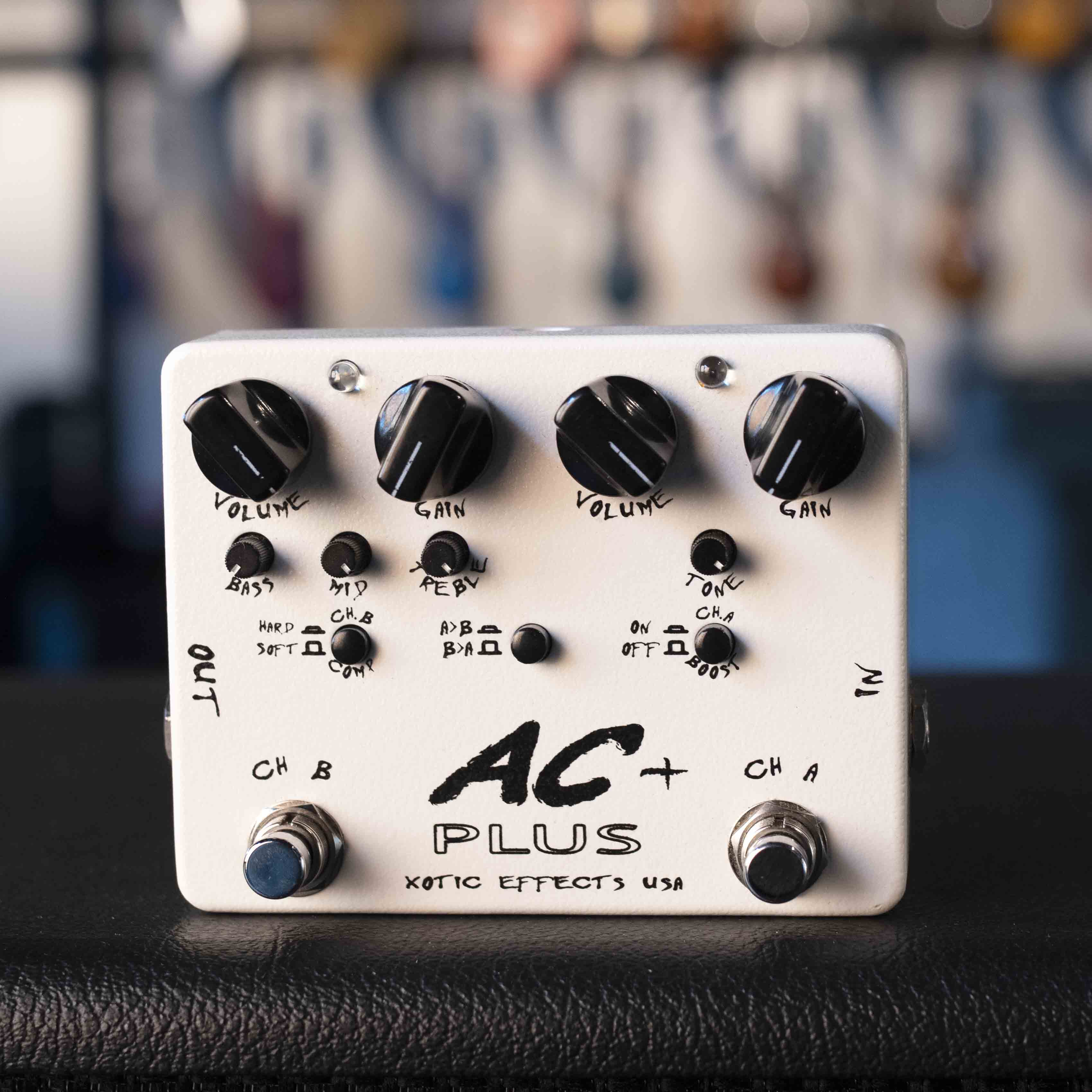 White guitar effects pedal with multiple control knobs, two footswitches, and input/output jacks on sides.