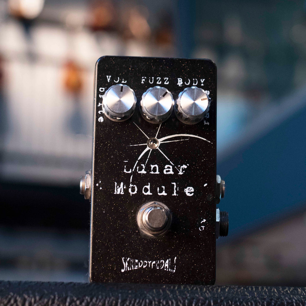 Black guitar pedal with three silver knobs and one footswitch labeled Lunar Module and SKREDDYPEDALS.