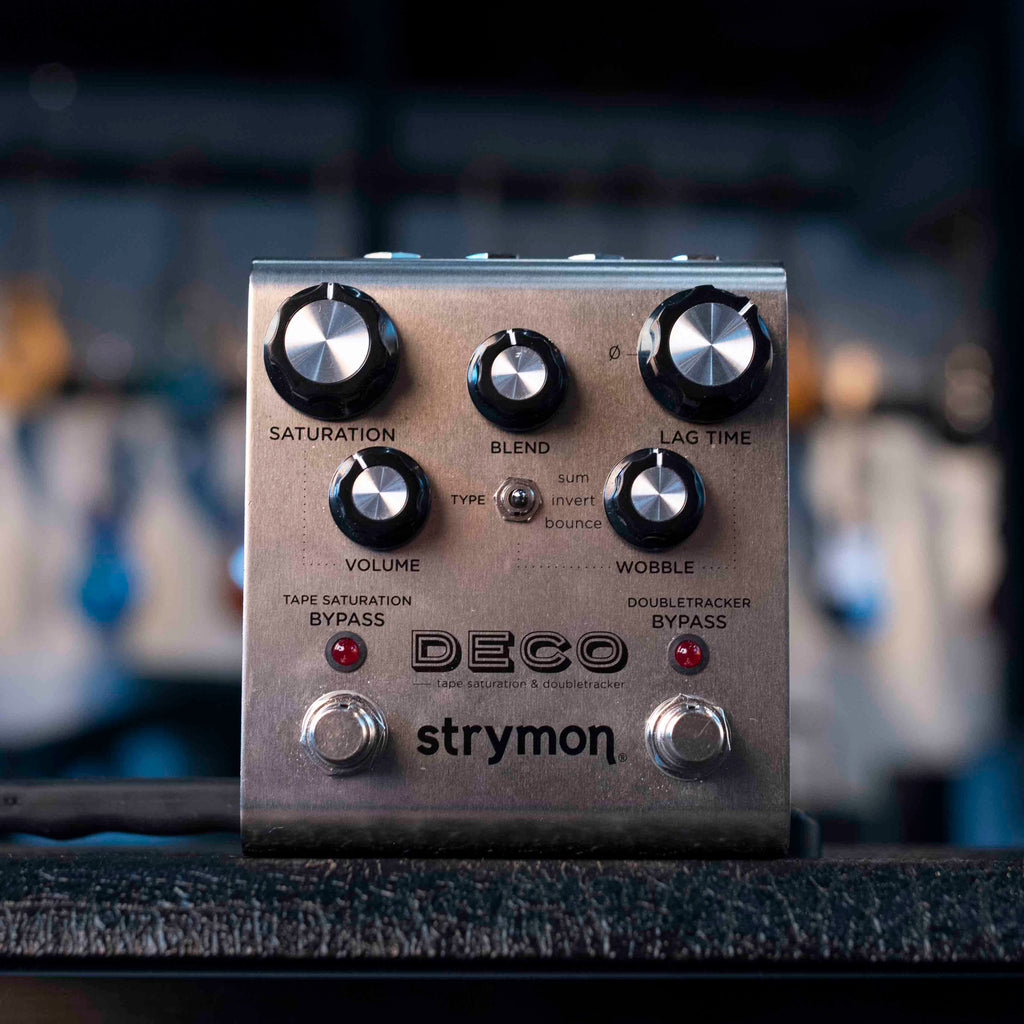 Silver Strymon Deco modulation pedal with multiple knobs, a toggle switch, and two footswitches on a black surface.