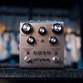 Silver Strymon Deco modulation pedal with multiple knobs, a toggle switch, and two footswitches on a black surface.