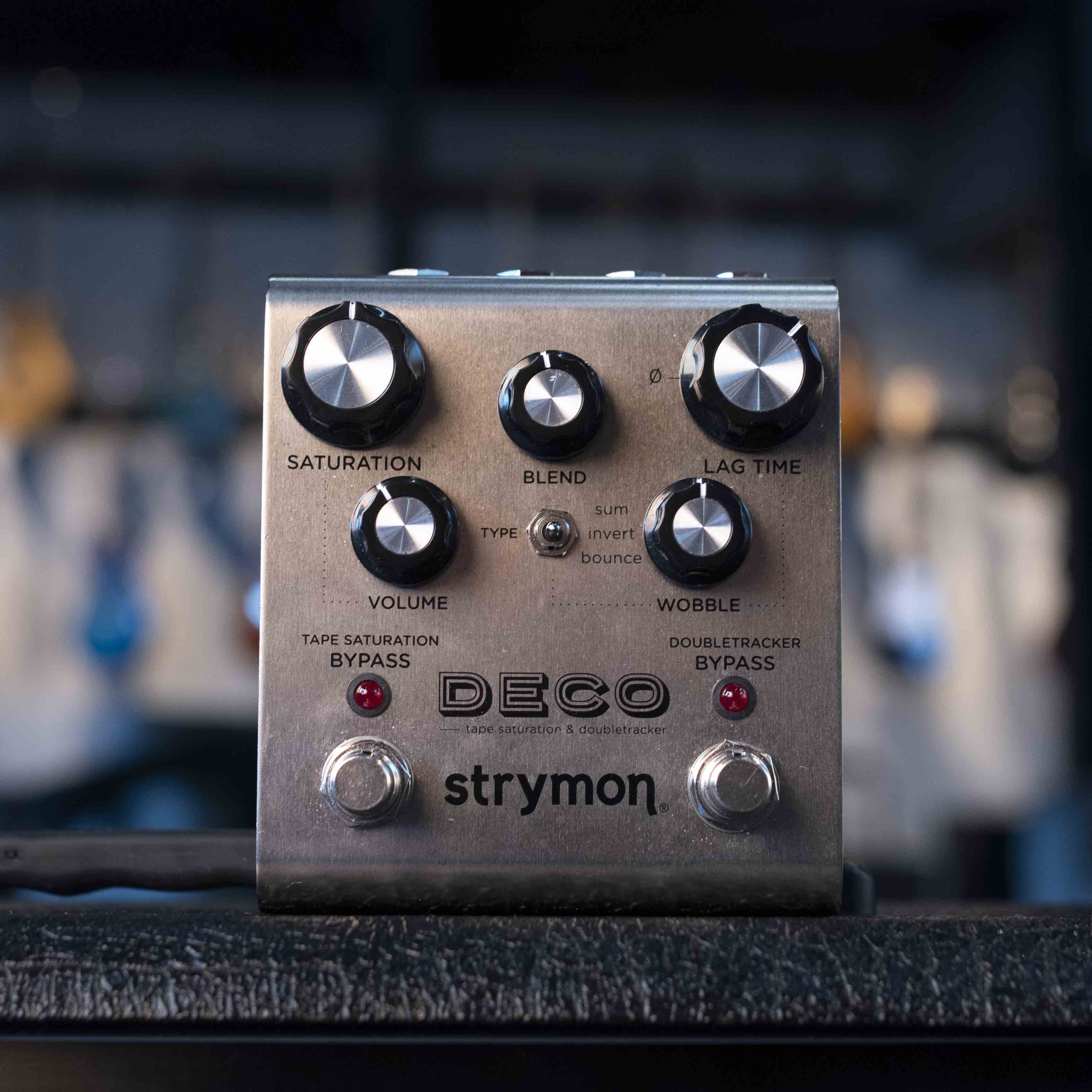 Silver Strymon Deco modulation pedal with multiple knobs, a toggle switch, and two footswitches on a black surface.