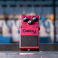 Red Boss Delay DM-2 guitar effects pedal with three control knobs and input/output jacks.
