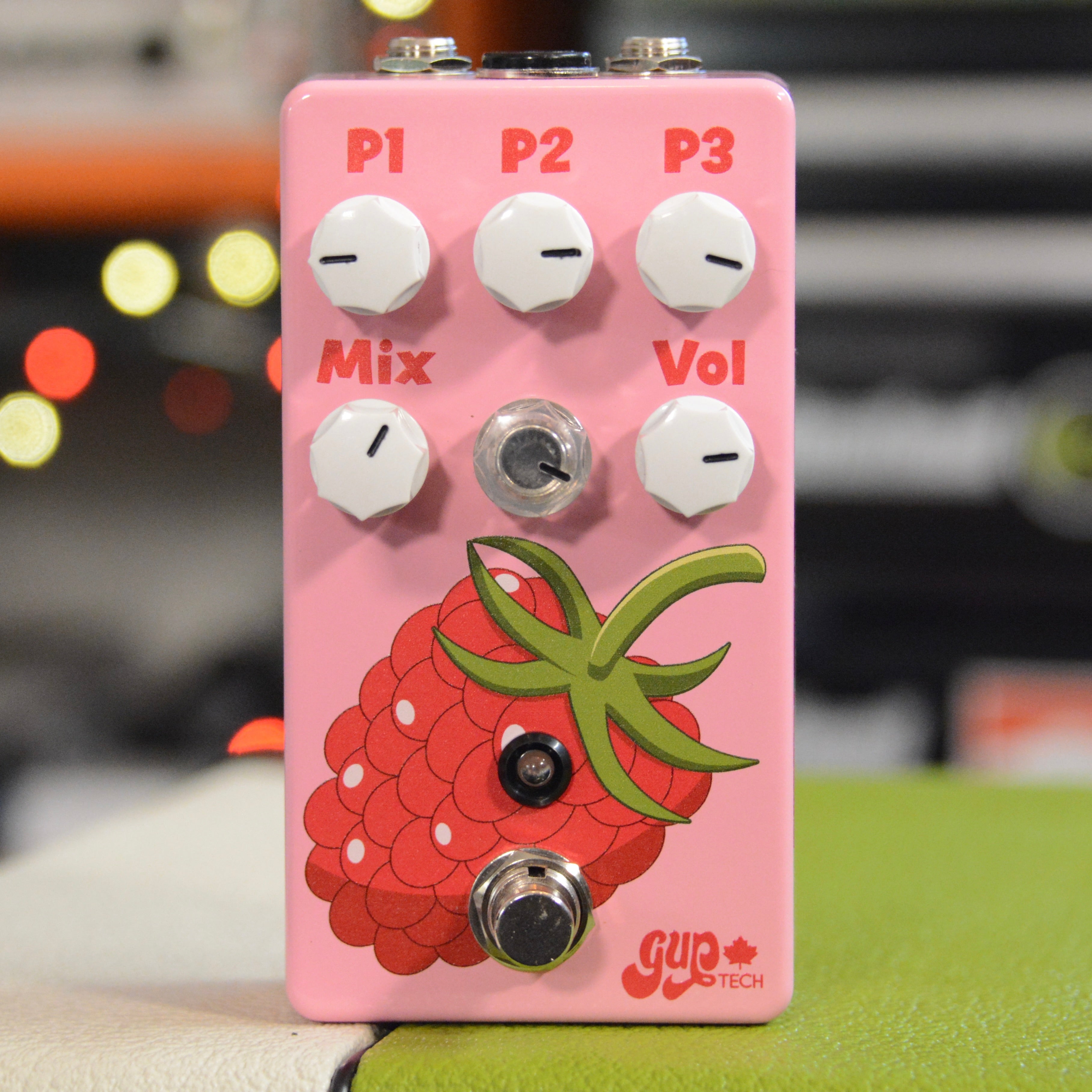 Pink guitar effects pedal with white knobs, a footswitch, and raspberry graphic on front panel.