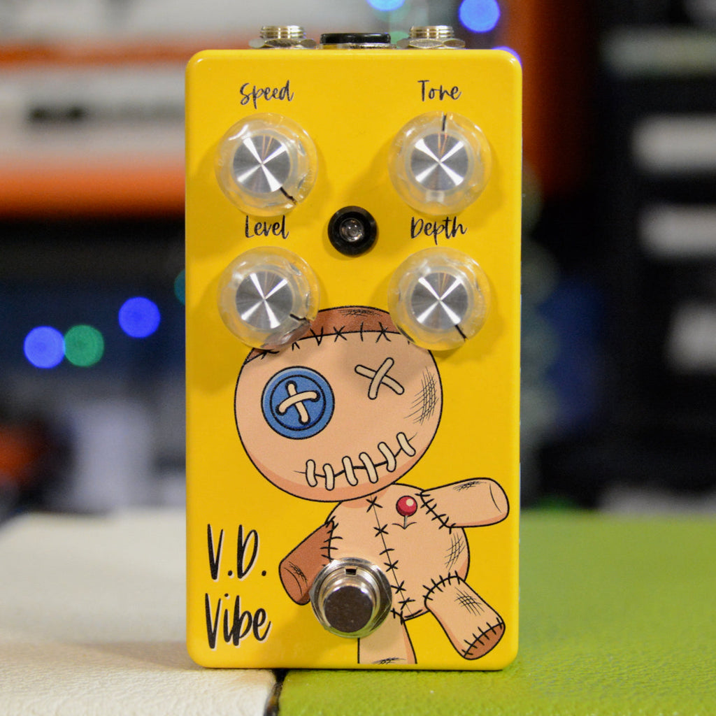 Yellow guitar effects pedal with four knobs labeled Speed, Tone, Level, Depth and a footswitch, featuring a stitched doll graphic.