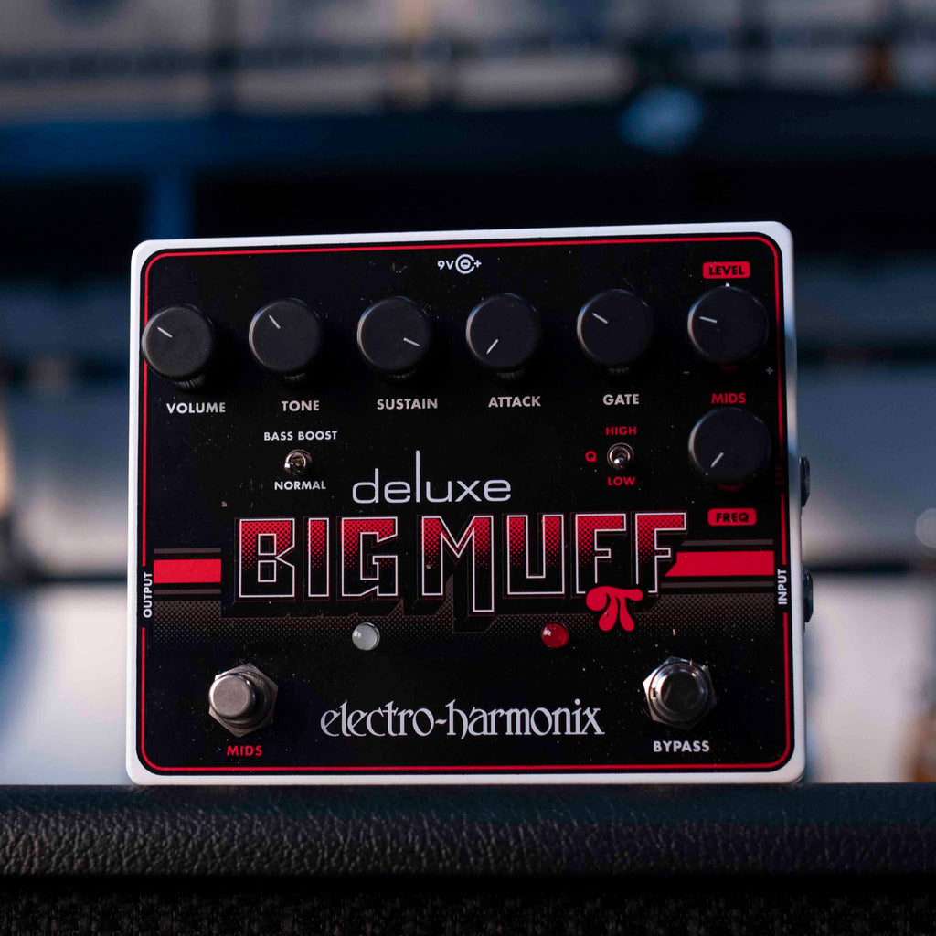 Electro-Harmonix Deluxe Big Muff guitar effects pedal with six knobs, two footswitches, and toggle switches on black panel.