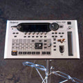 Top view of a silver Roland VG-99 multi-effects guitar processor with display, knobs, buttons, and ribbon controller.