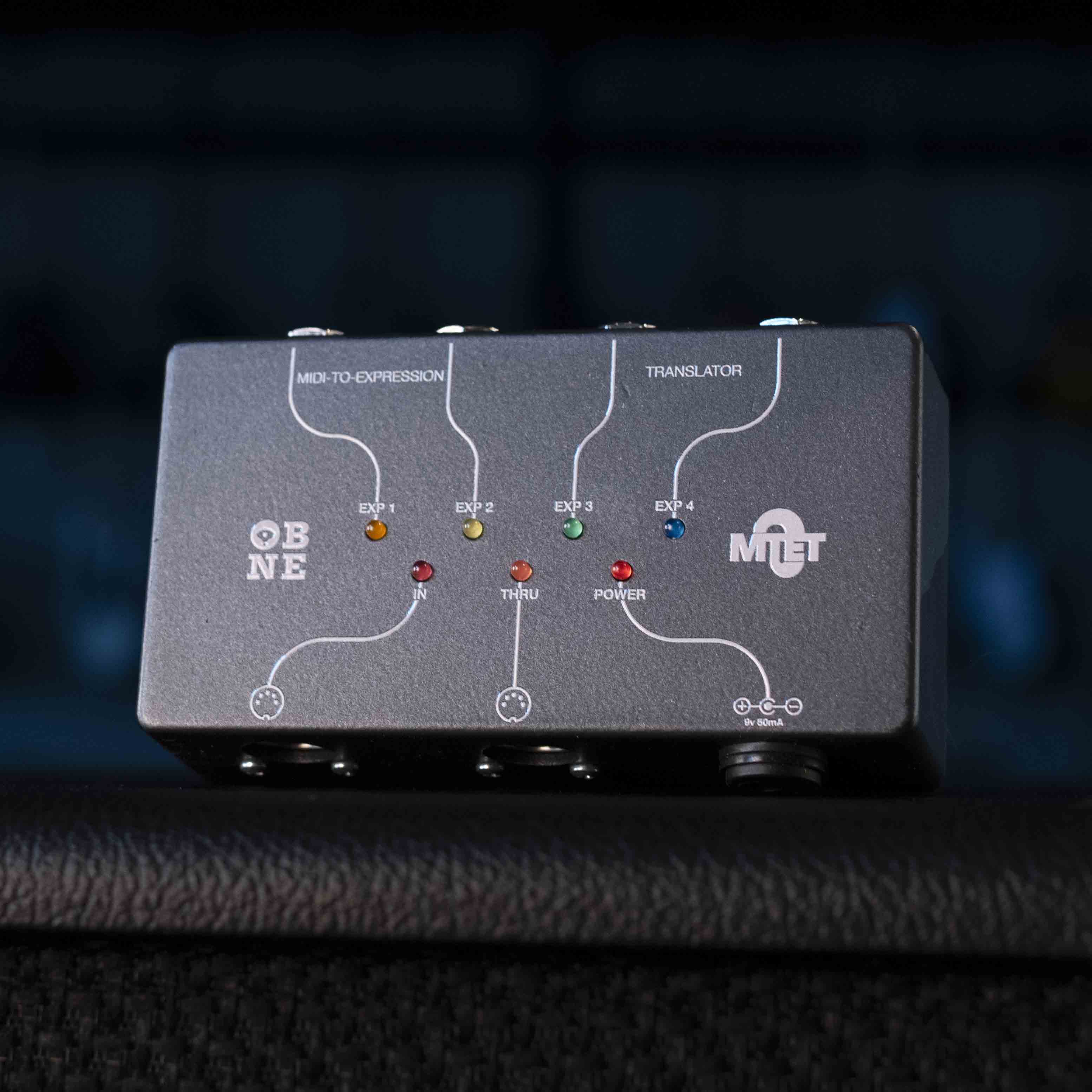 Black MIDI to expression translator device with LED indicators and MIDI ports labeled for input, thru, and expression outputs.