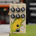 Cream colored guitar pedal with six black knobs and artwork of corn and popcorn.
