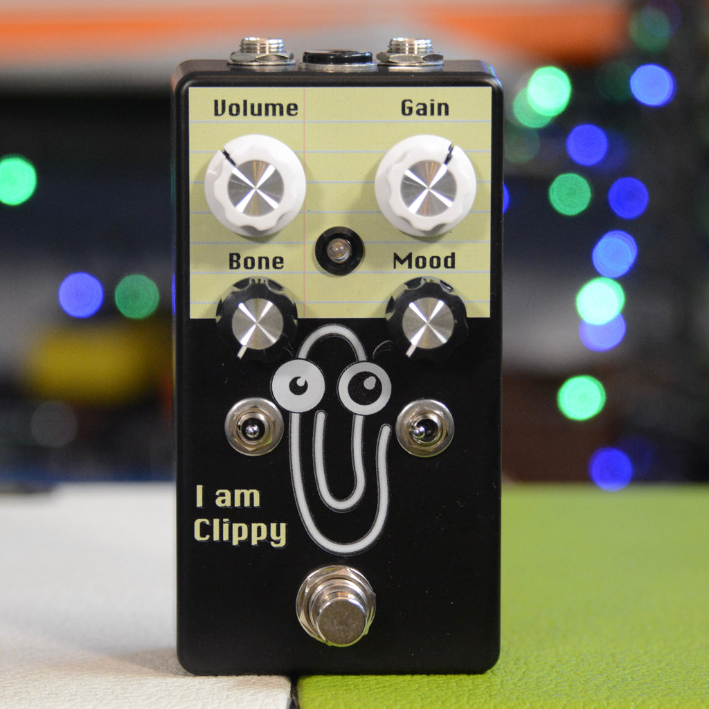 Black guitar effects pedal with four knobs, two toggle switches, one footswitch, and a cartoon paperclip graphic.