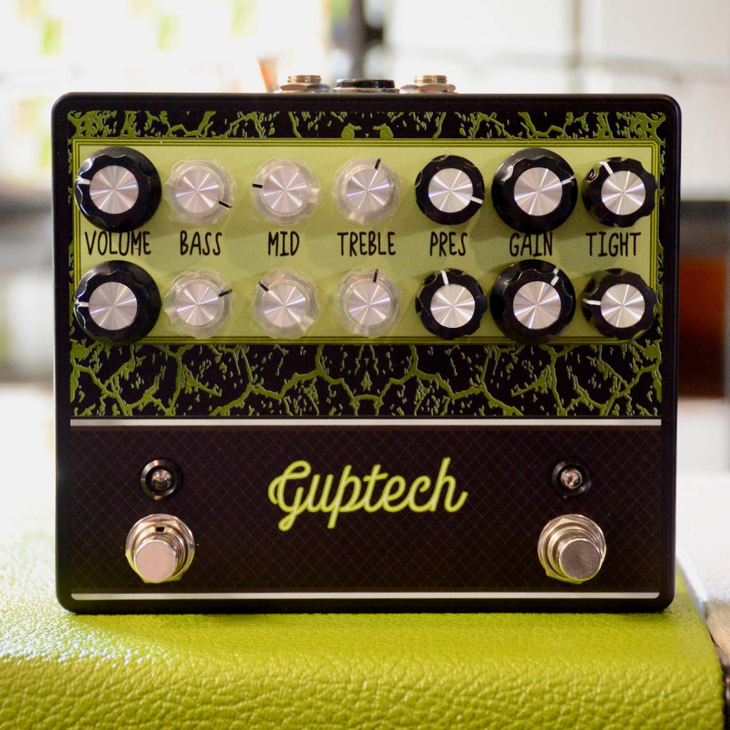 Black and green guitar effects pedal with two footswitches and multiple control knobs for volume, bass, mid, treble, presence, gain, and tight.