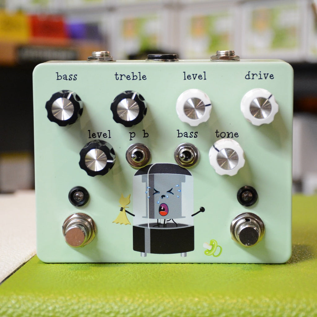 Light green guitar pedal with black and white knobs, two toggle switches, and cartoon illustration on front panel.