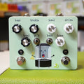 Light green guitar pedal with black and white knobs, two toggle switches, and cartoon illustration on front panel.