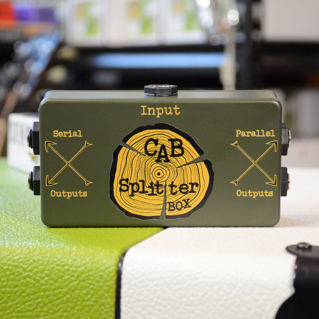 Green metal box with connectors and a knob labeled Cab Splitter Box, showing input and output labels.