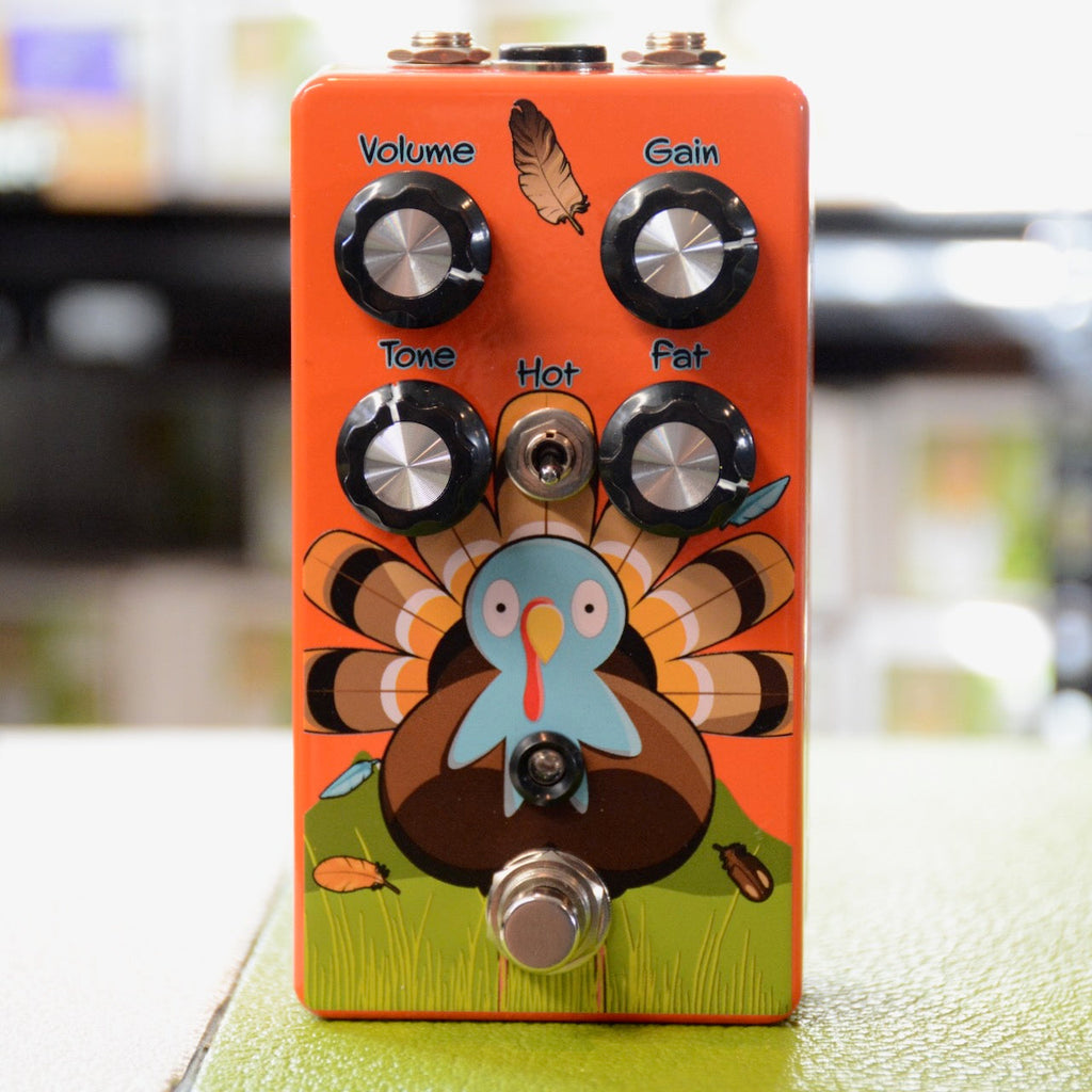 Orange guitar effects pedal with cartoon turkey graphic, four control knobs, a toggle switch, and a footswitch.