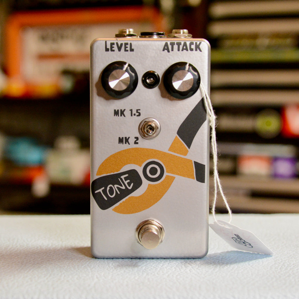 Silver guitar effects pedal with two black knobs, toggle switch, footswitch, and orange pliers graphic labeled 'TONE'
