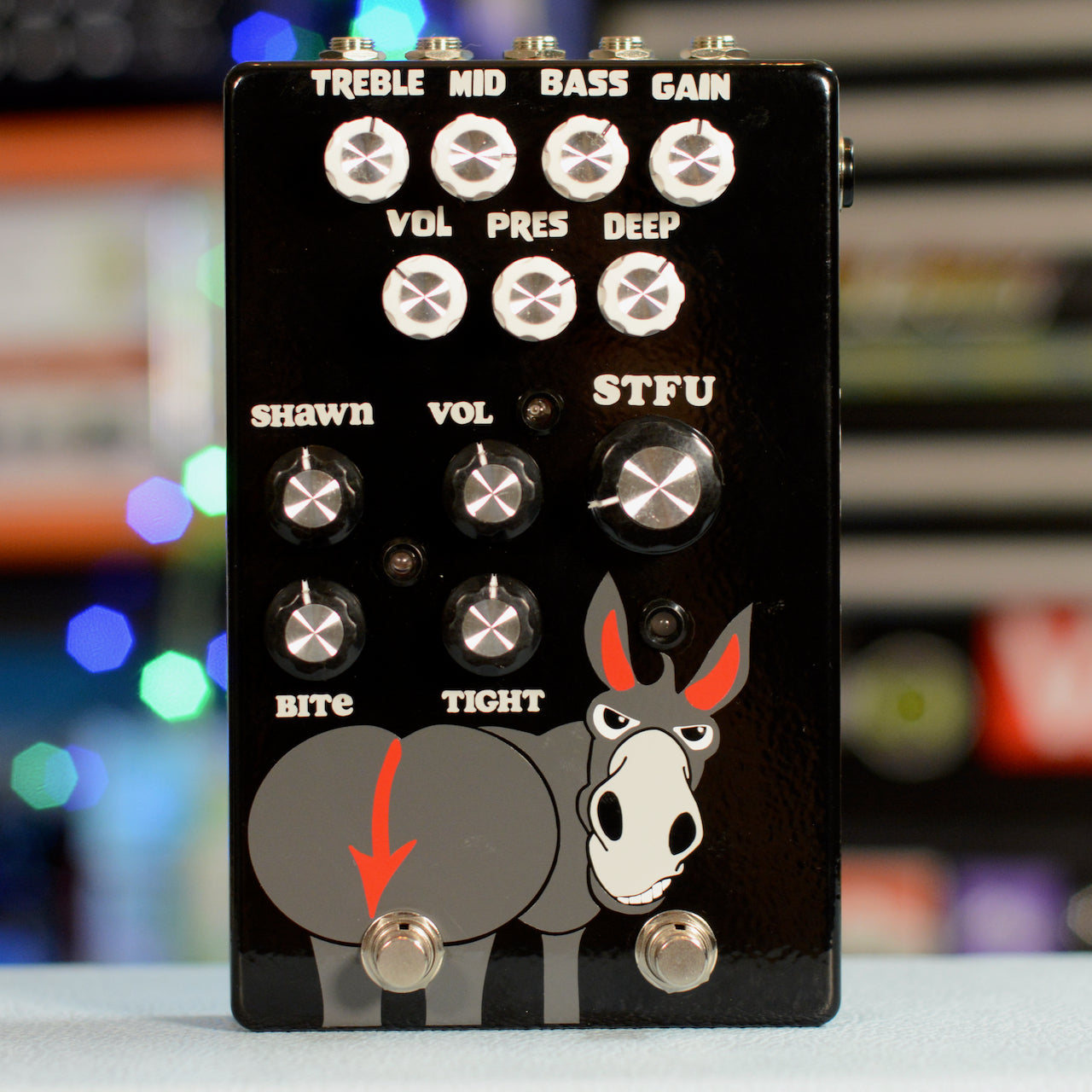 Black guitar effects pedal with multiple control knobs and two footswitches featuring a cartoon donkey graphic.