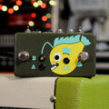 Dark green rectangular pedal with yellow fish graphic, two footswitches, and jacks labeled A, B, and AB.