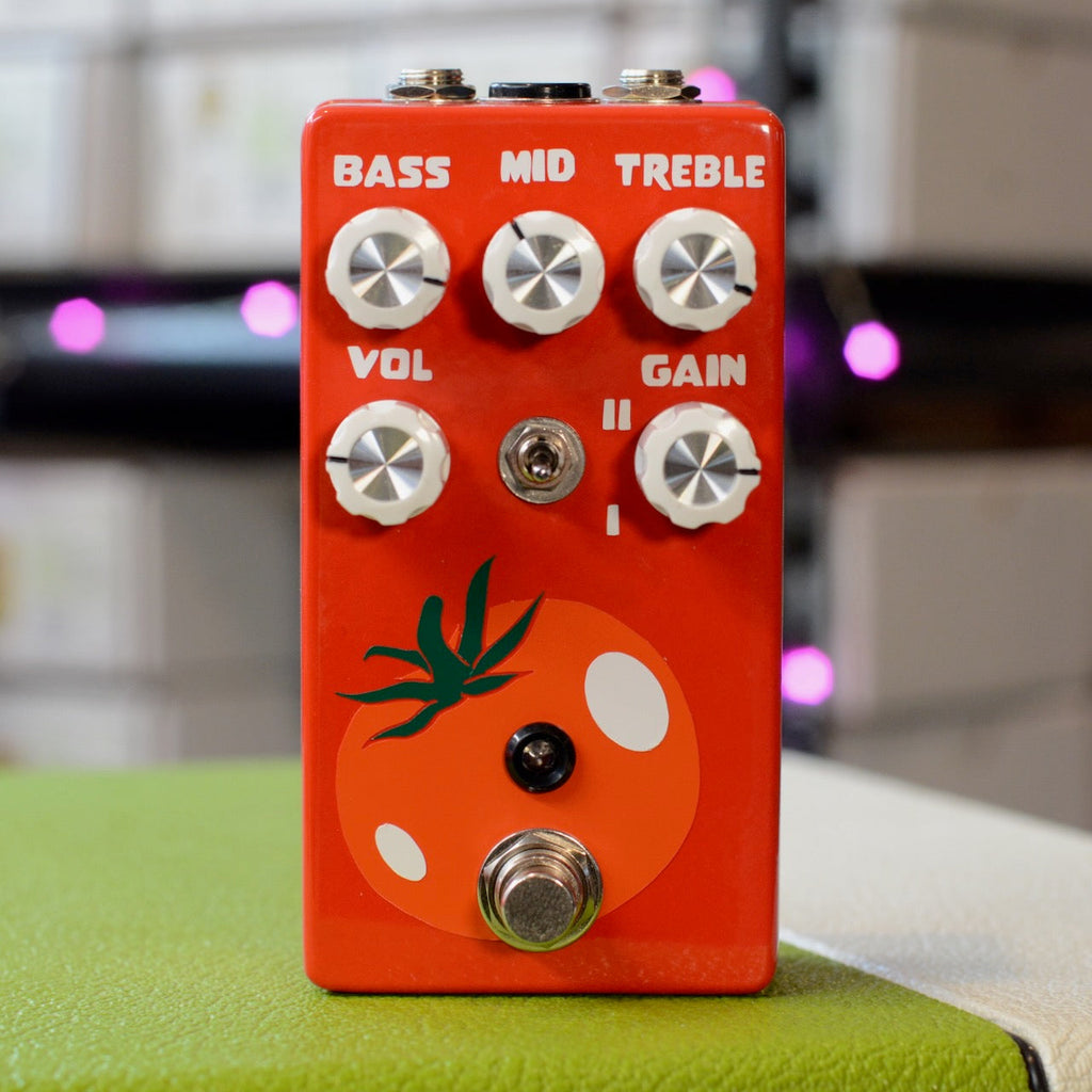 Red guitar effects pedal with five knobs, a toggle switch, a footswitch, and tomato graphic on front.
