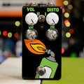 Black guitar effects pedal with green, orange, and yellow torch flame graphic, four knobs, a toggle switch, and a footswitch.