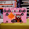 Pink guitar effects pedal with multiple knobs and three footswitches, decorated with a beaver and flame graphic.