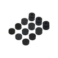 Black cylindrical rubber grommets with and without center holes arranged on a white background.