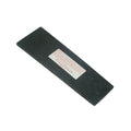 Black rubber replacement tread for a pedal with a warning label attached