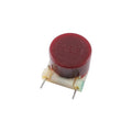 Red cylindrical electronic component with the text FASEL and two metal wire leads on a white base.