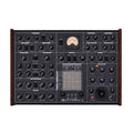 Top-down view of a black Erica Synths SYNTRX II synthesizer with multiple knobs, switches, a joystick, and a VU meter.