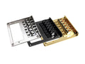 Three metal guitar bridges in silver, black, and gold finishes arranged in a row on white background.