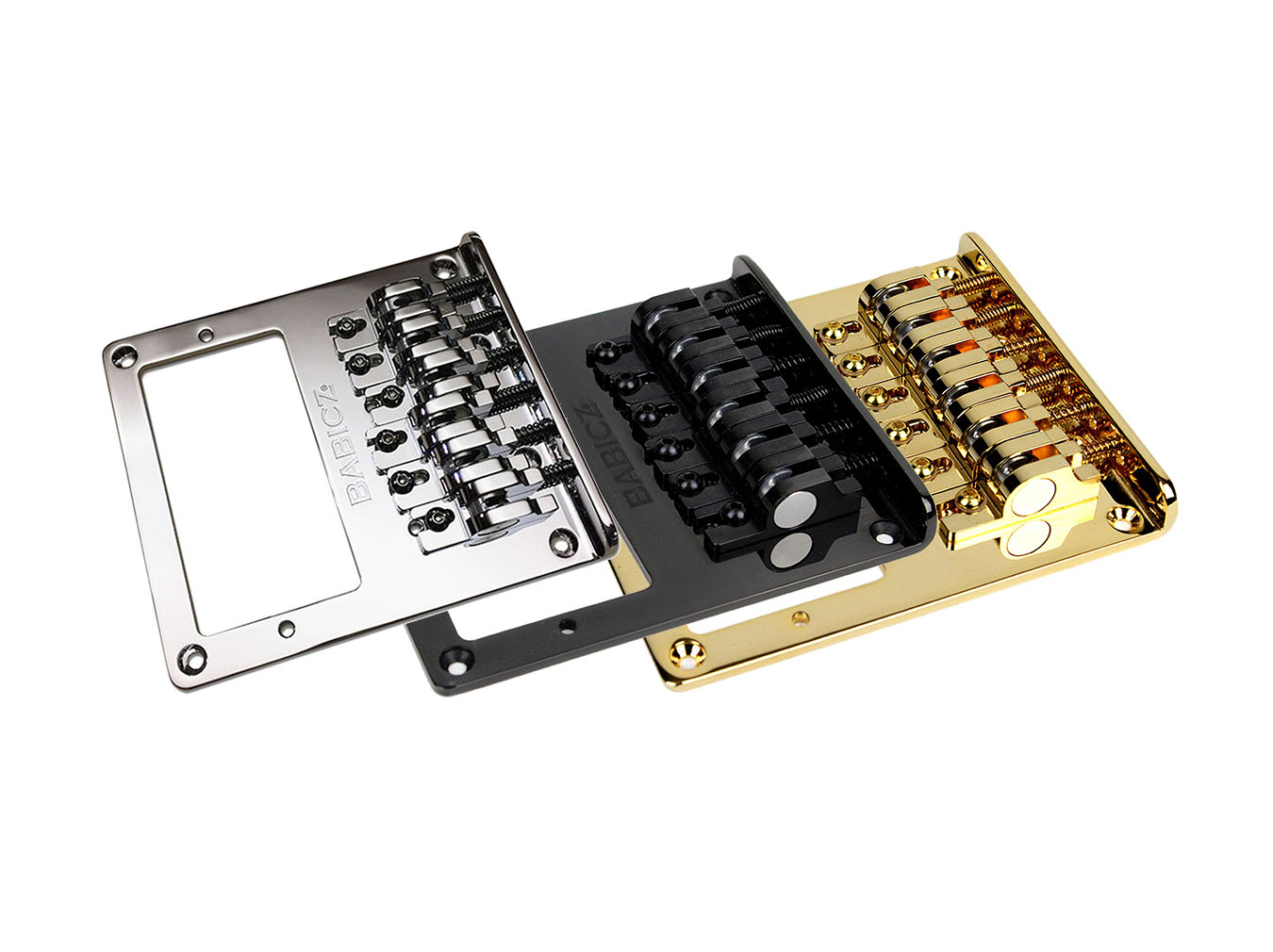 Three metal guitar bridges in silver, black, and gold finishes arranged in a row on white background.